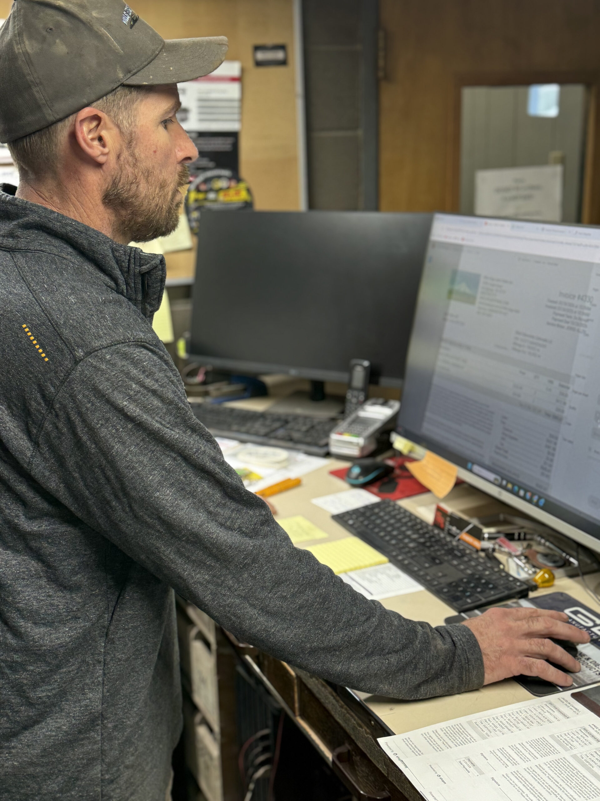 Auto repair service advisor reviewing customer information at computer